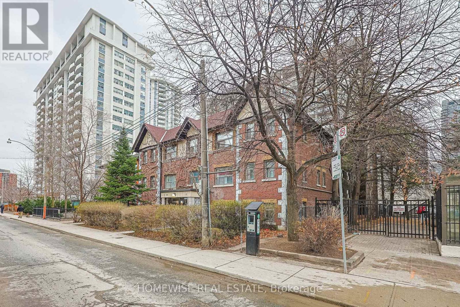 A street view of a residential area with a tall building in the background.