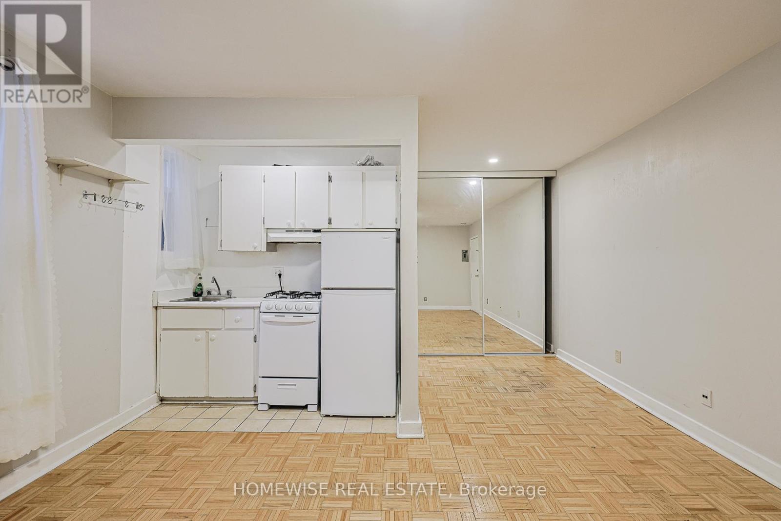 A kitchen area with a white fridge, dishwasher, and stove.