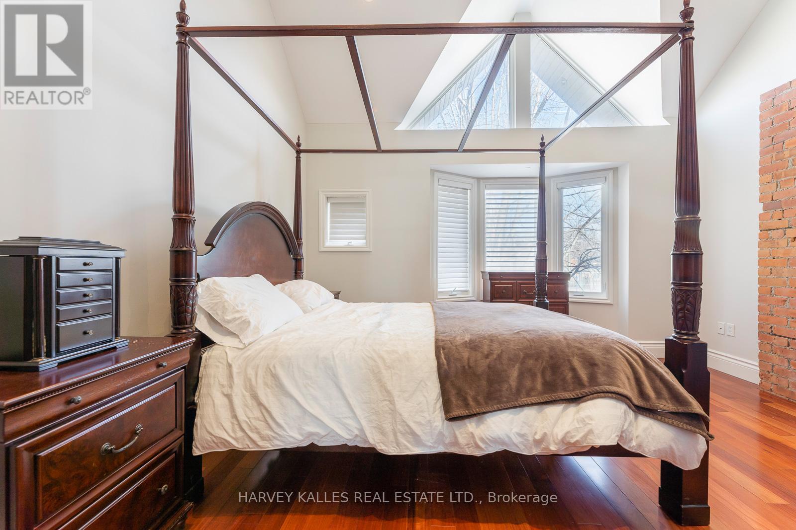 A bedroom with a four poster bed and a dresser.