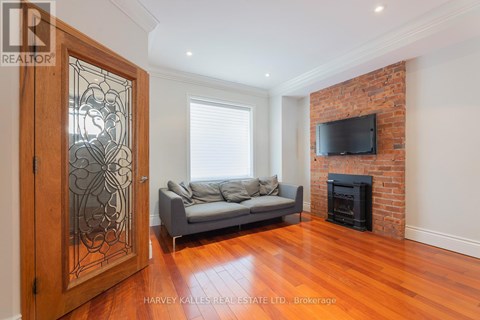 A living room with a grey couch and a fireplace.