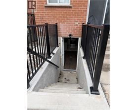 A black gate is on the side of a staircase.
