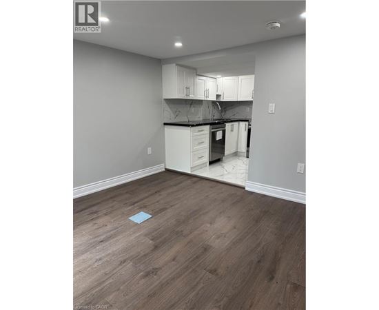 A kitchen with white cabinets and a wooden floor.