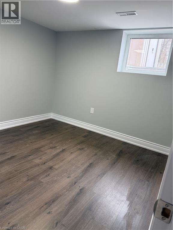 A room with a window and wooden flooring.