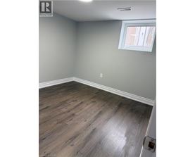 A room with a window and wooden flooring.