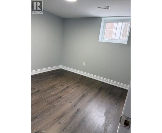 A room with a window and wooden flooring.