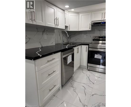 A kitchen with white cabinets and marble countertops.