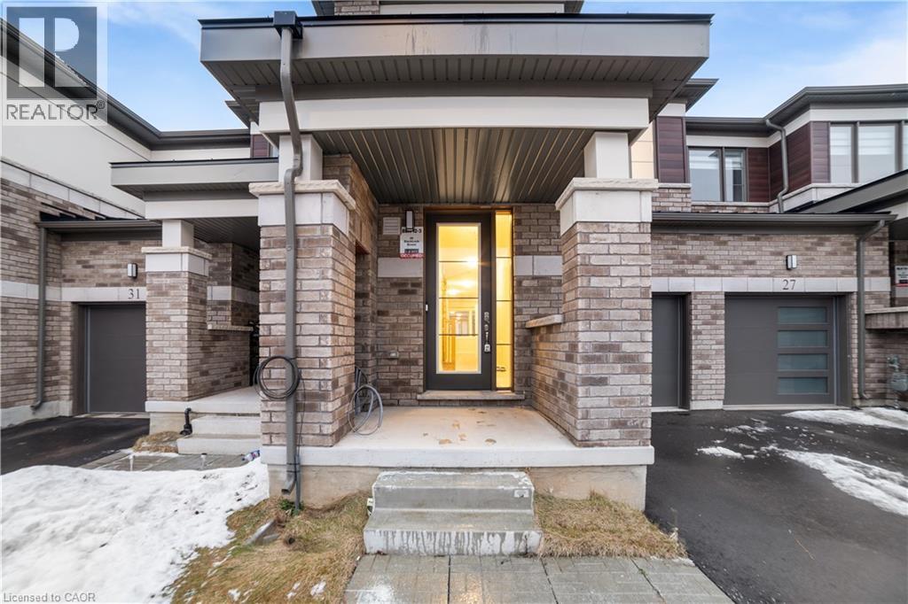 A modern house with a yellow door and a stone facade.