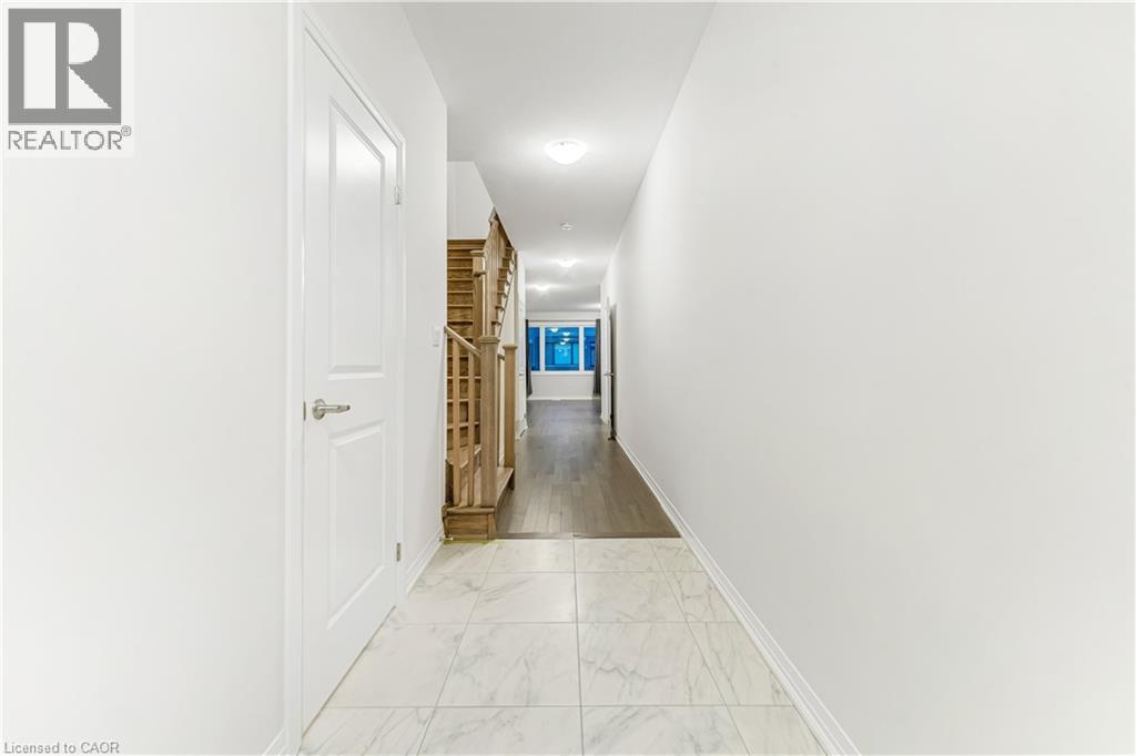 A long hallway with a white door on the left and a blue door in the distance.