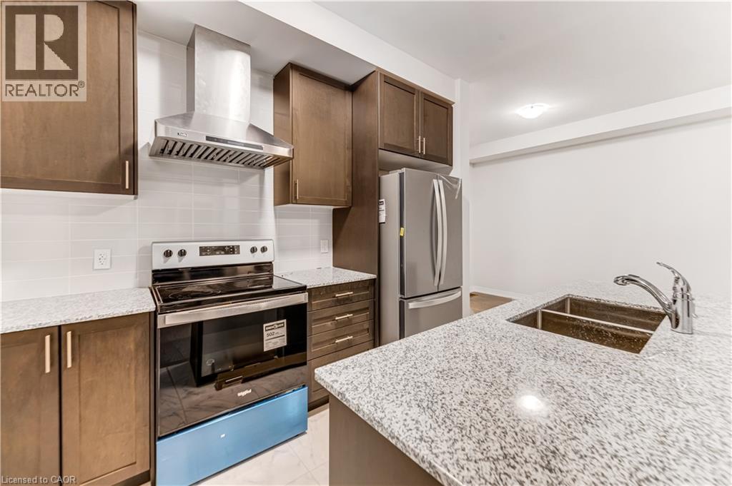 A kitchen with a stove top oven and a refrigerator.