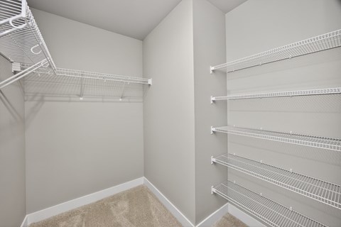 Empty white shelves in a corner of a room.