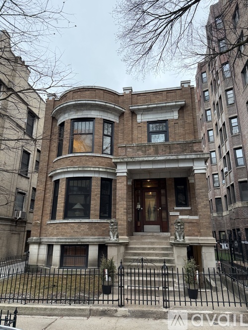 A large, old building with a black iron fence in front.