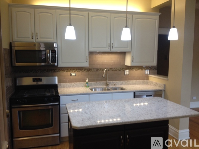 A kitchen with a granite countertop and white cabinets.