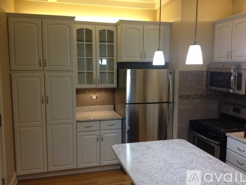 A kitchen with white cabinets and a granite countertop.