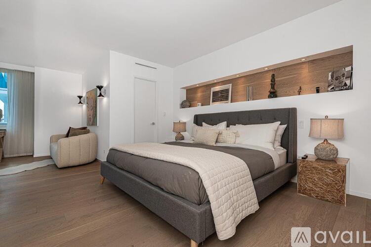 A bedroom with a large bed and a wooden headboard.