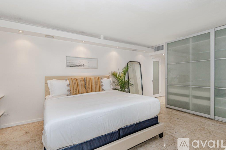 A bedroom with a large bed and a glass door.