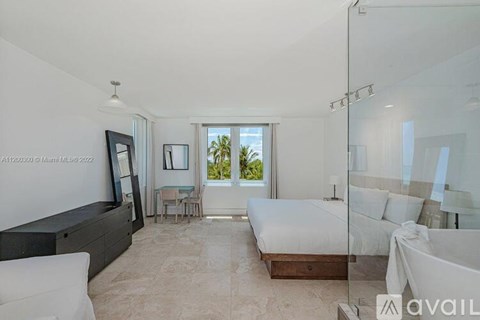 A bedroom with a large bed and a view of the outdoors through a window.