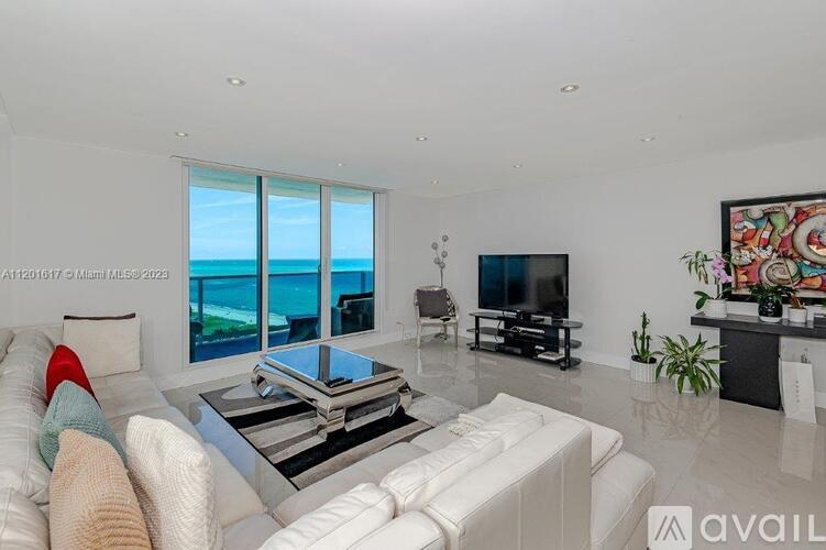 A living room with a white couch and a television.