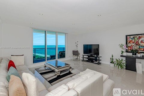 A living room with a white couch and a television.