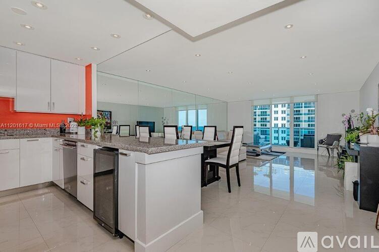 A modern kitchen with white cabinets and a central island.