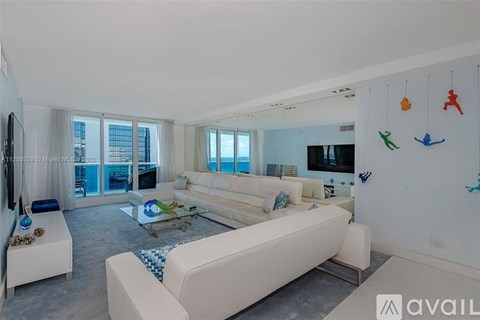 A living room with white furniture and a large window.