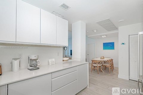A kitchen with white cabinets and a wooden table.