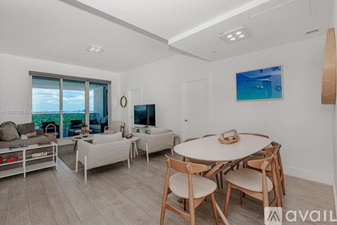 A living room with a white couch, a white coffee table, and a painting on the wall.