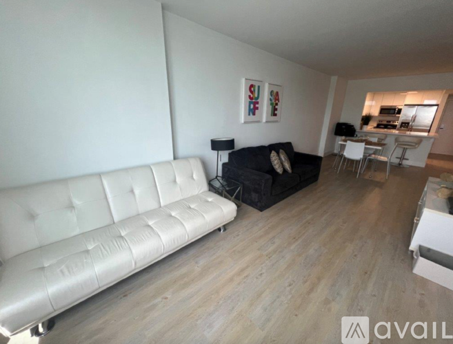 A living room with a white couch and a black couch.