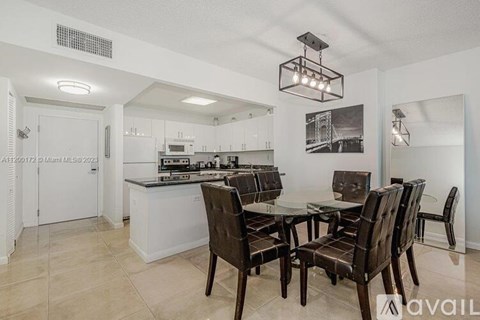 A kitchen with a table and chairs in the foreground.