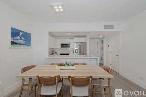 A dining room with a wooden table and chairs.