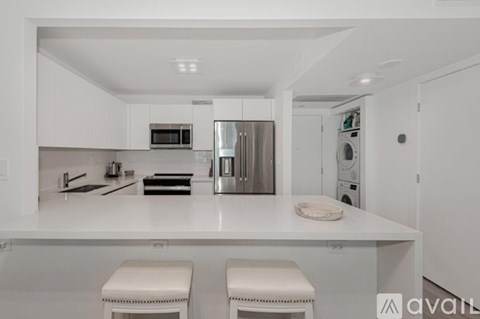 A modern kitchen with white cabinets and appliances.