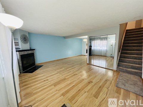 A room with wooden flooring and a fireplace.