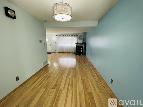 A room with wooden flooring and a light hanging from the ceiling.
