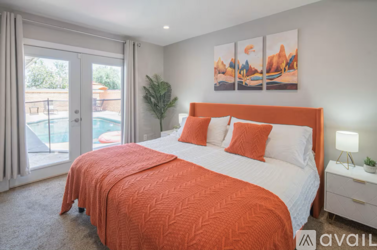 A bedroom with a large bed and a painting on the wall.