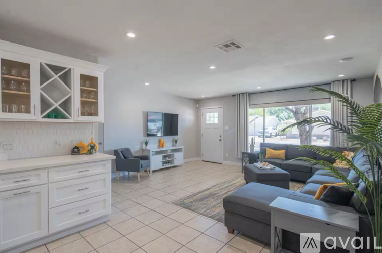 A living room with a grey couch and a white cabinet.