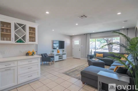 A living room with a grey couch and a white cabinet.