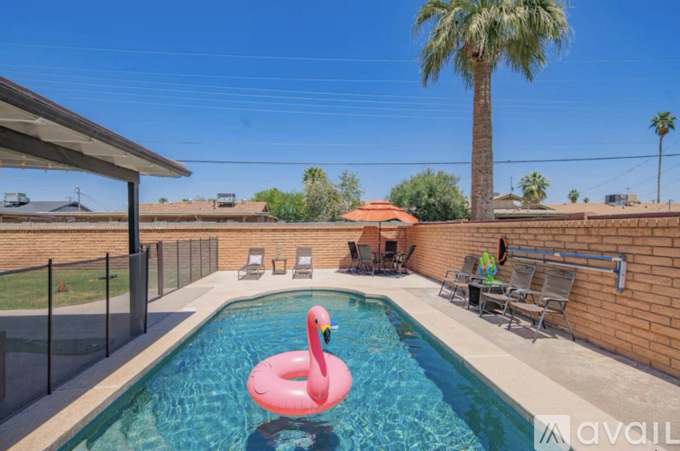 A pool with a pink flamingo float in the middle of it.