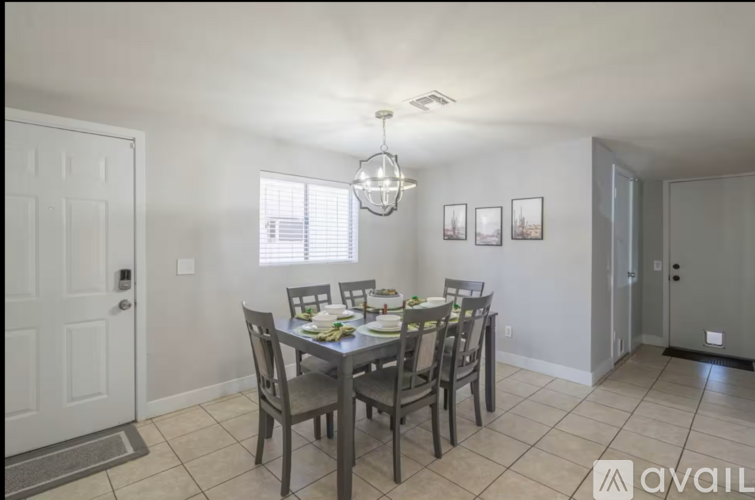 A dining room with a table set for six people.