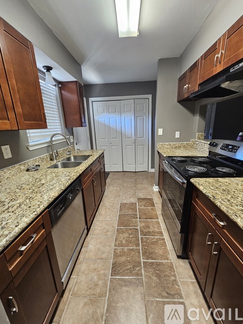 A kitchen with brown cabinets and granite countertops.