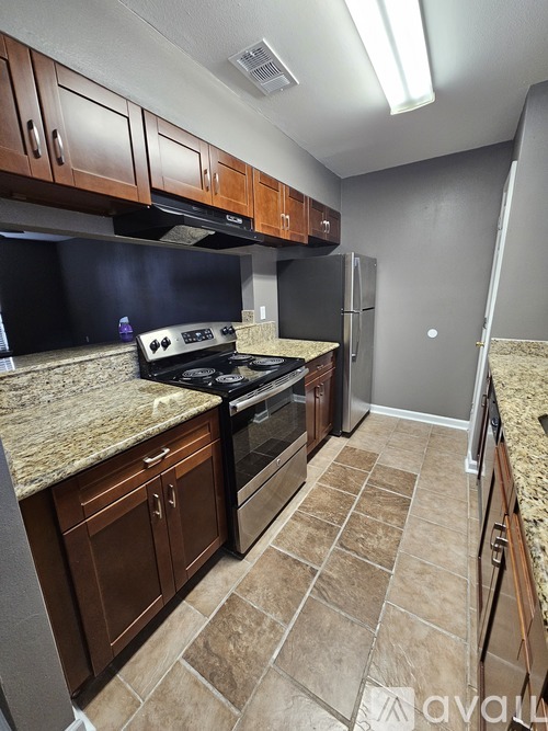 A kitchen with brown cabinets and a black stove top oven.