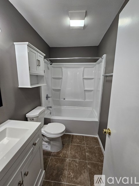 A bathroom with a toilet, sink, and bathtub.