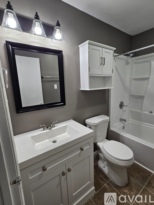 A bathroom with a white toilet, sink, and bathtub.