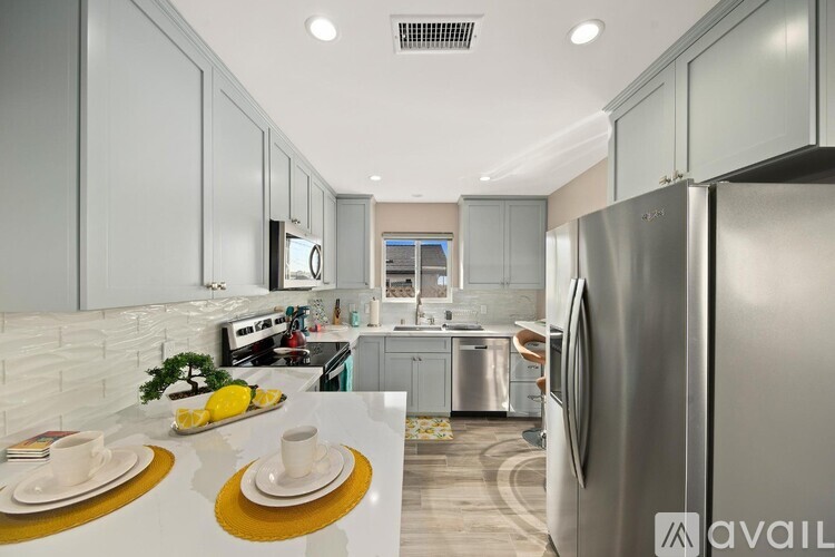 A modern kitchen with a refrigerator on the right side.