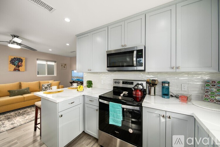A kitchen with white cabinets and a black stove top oven.