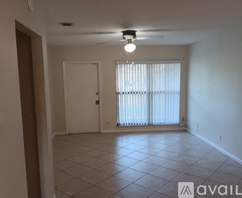 A room with a ceiling fan and a window with blinds.