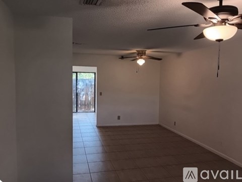 A room with a ceiling fan and a light hanging from it.