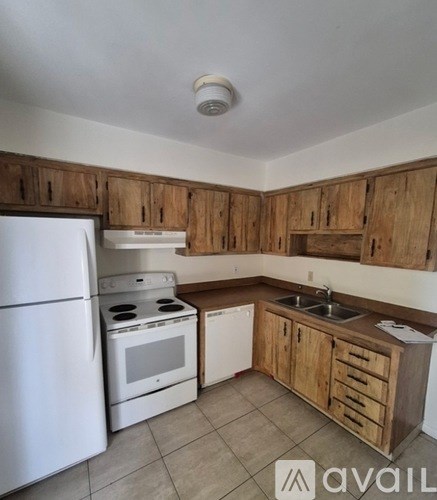 A kitchen with wooden cabinets and white appliances.