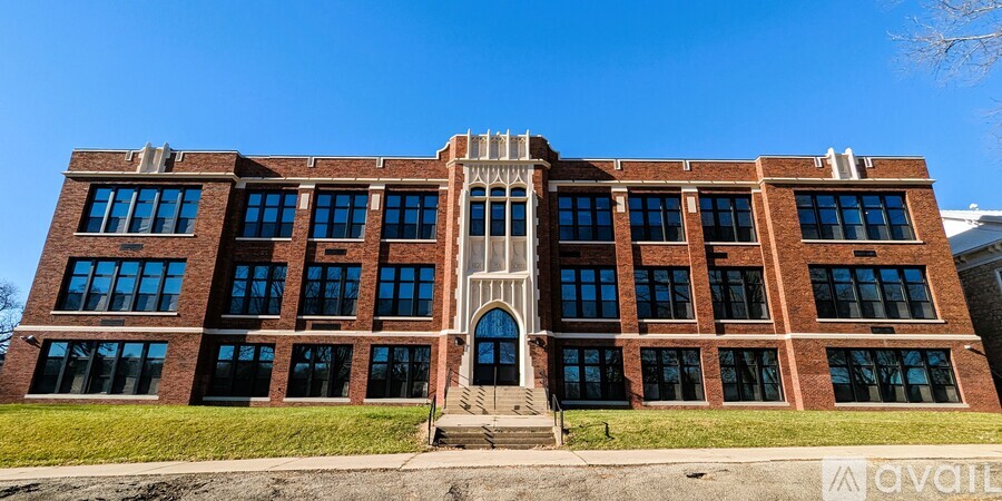 A large red brick building with a central arched entrance.