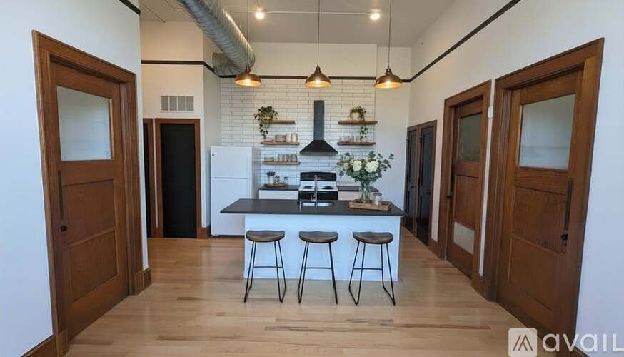 A kitchen with a black countertop and a white fridge.