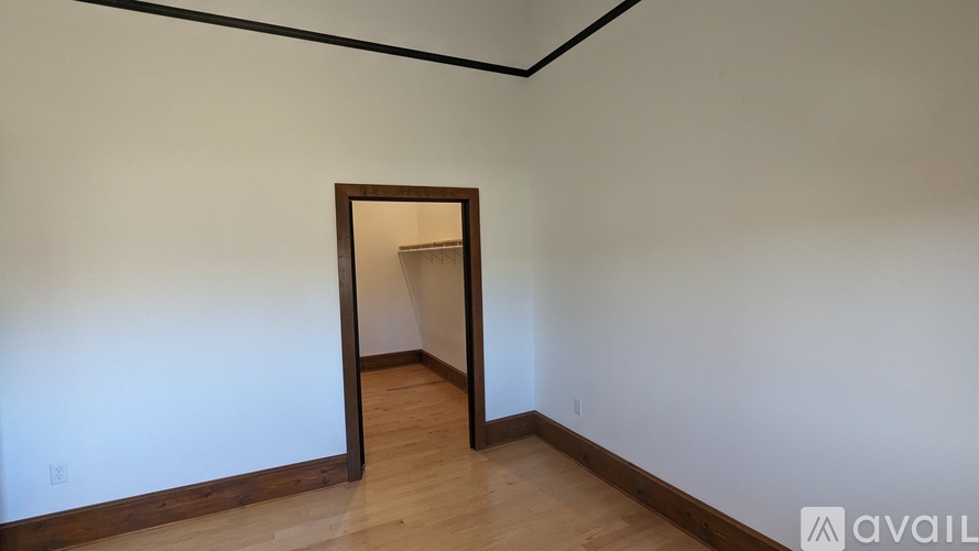 A room with a wooden floor and a mirror on the wall.