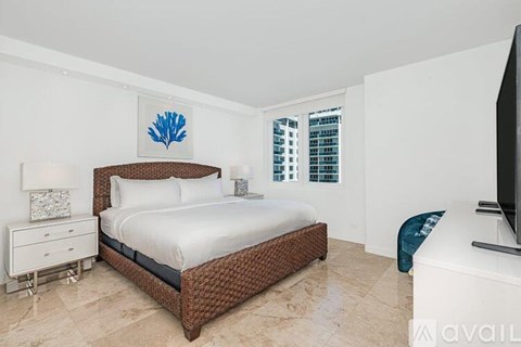 A bedroom with a large bed and a flat screen TV.